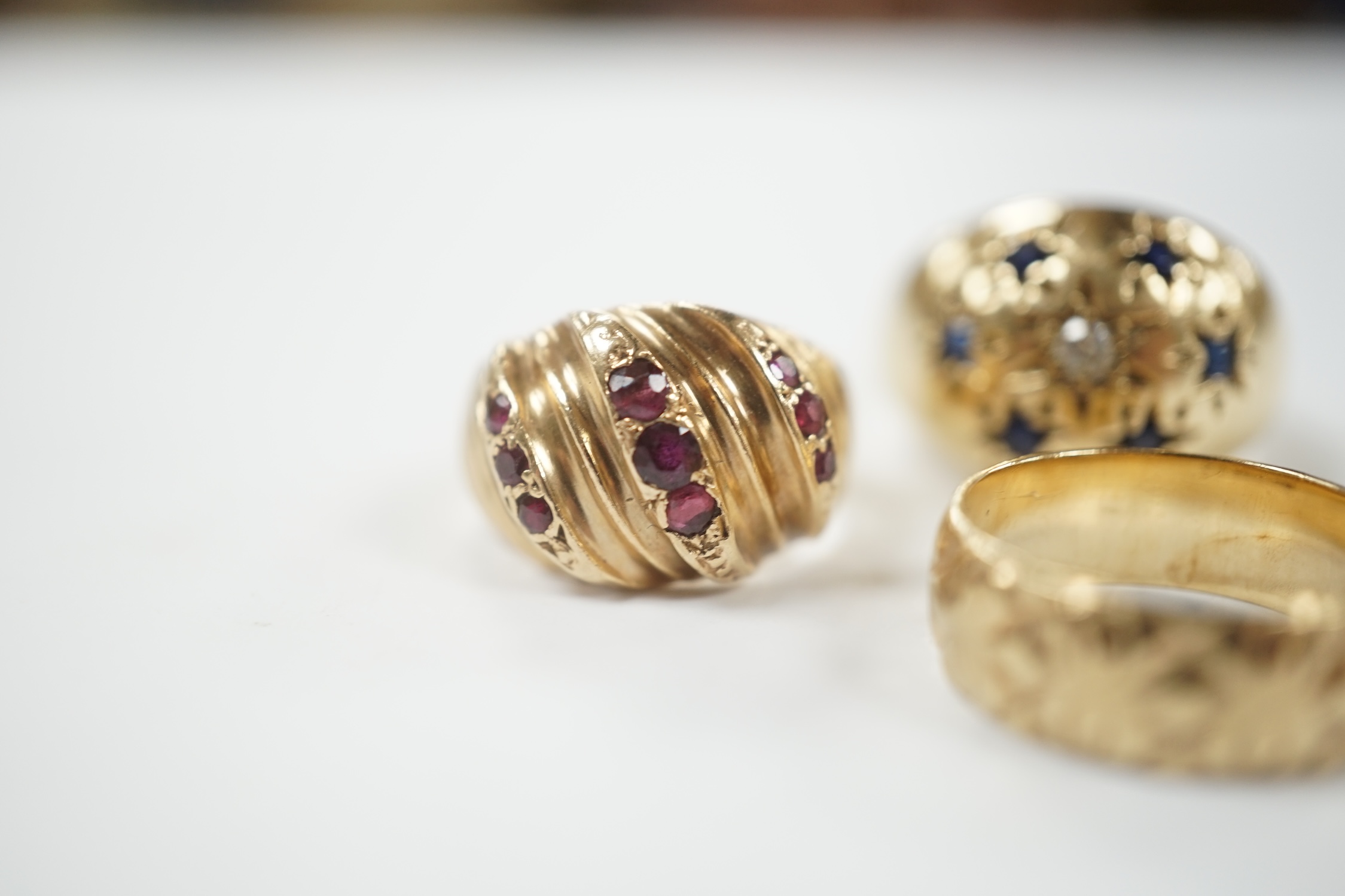 Two modern 9ct gold and gem set dress rings and a similar engraved 9ct gold band